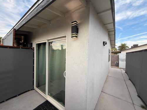 a white building with a sliding glass door at Modern Guesthouse W Parking 12Min to Strip in Las Vegas