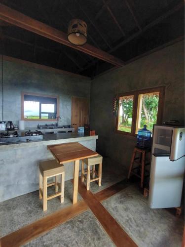 a kitchen with a wooden table and a refrigerator at Baan Dee Dee in Ko Phayam