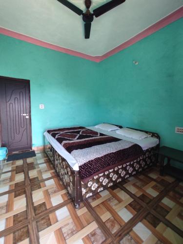 a bed in a room with green walls and a ceiling at Nanda Devi Home Stay in Sari