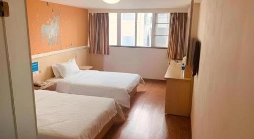 a hotel room with two beds and a television at 7 Days Inn Chengdu North Railway Metro Station in Chengdu