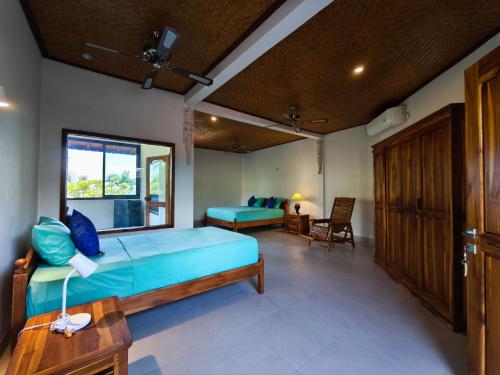 a bedroom with a blue bed and a desk at 1000 Dream Bungalow in Lovina