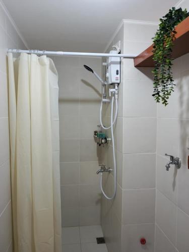 a bathroom with a shower with a shower curtain at Mistow MarinaSpatial Dumaguete in Piapi