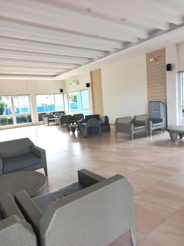 a lobby with couches and chairs in a building at Mistow MarinaSpatial Dumaguete in Piapi