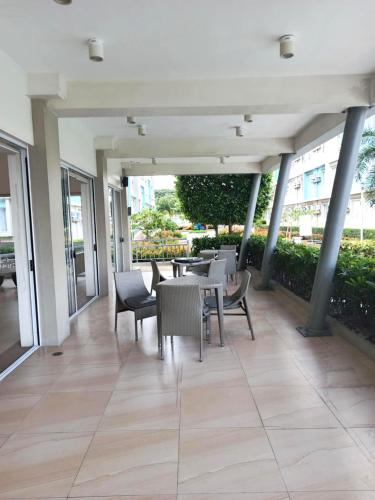 a patio with tables and chairs in a building at Mistow MarinaSpatial Dumaguete in Piapi