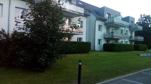 an apartment building with a green lawn in front of it at Le Roi du Sundgau près de la Horse - Mooslargue in Mooslargue