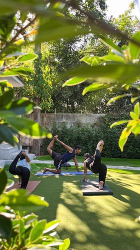 a group of people doing yoga in the grass at Moorea Boutique Resort Samui in Ban Tai