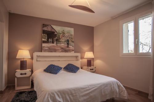 ファイエンスにあるLes chambres du Restaurant le Castellaras - Teritoriaのベッドルーム1室(ベッド1台付)が備わります。壁には絵画が飾られています。