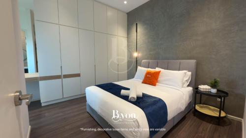 a bedroom with a large bed with orange and white pillows at Onsen Premium Suites @ Tambun Ipoh in Ipoh