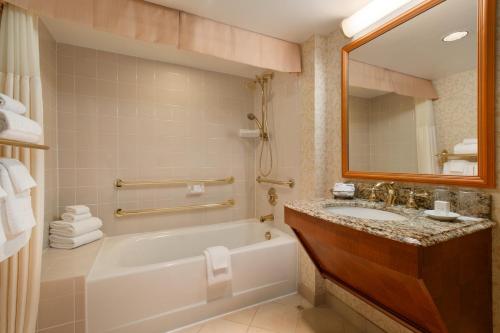 a bathroom with a tub and a sink and a mirror at Harrah's Casino & Hotel Council Bluffs in Council Bluffs