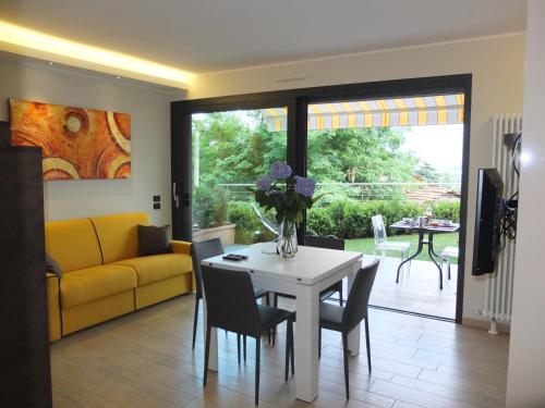 a living room with a table and a yellow couch at BELLA VITA Residence in Gravedona