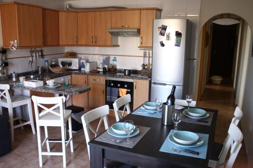 cocina con mesa, sillas y nevera en Beach House, en Los Cristianos