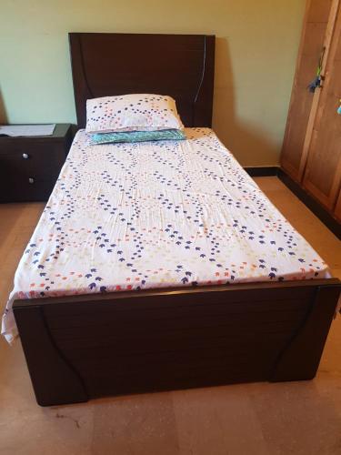 a bed in a room with a bedspread on it at Kashmir Girls Hostel Madina Town Faisalabad in Faisalabad