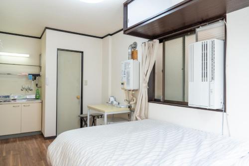 東京にあるKanamachi INN A-1の白いベッドと窓のある寝室