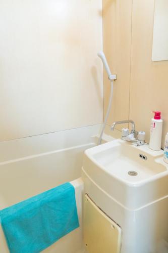 a white bathroom with a sink and a toilet at Kanamachi INN A-1 in Tokyo