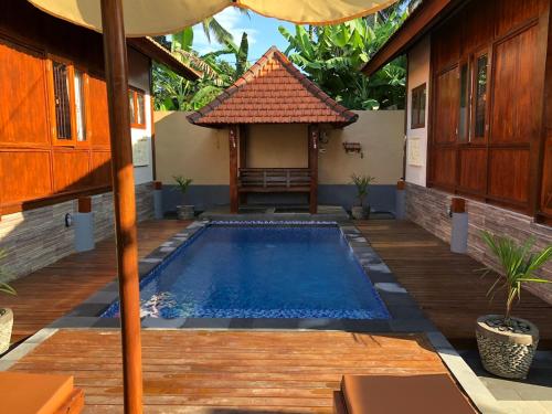a pool in the backyard of a house with an umbrella at Private Pool Retreat With Two Villas, Two Kitchens, Two Bathrooms, Perfect for Families and Friends Traveling Together in Ubud