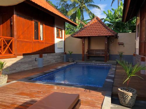 a house with a swimming pool in front of a house at Private Pool Retreat With Two Villas, Two Kitchens, Two Bathrooms, Perfect for Families and Friends Traveling Together in Ubud