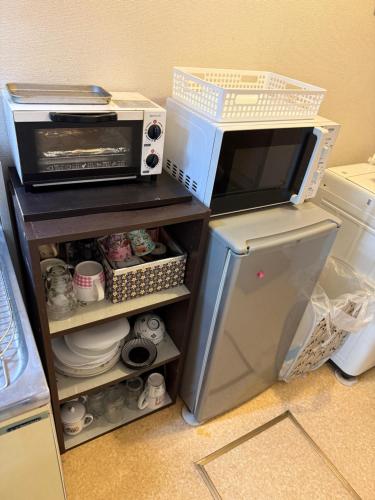 a kitchen with a microwave oven and a refrigerator at 17 minutes from Shinjuku, room 108 in Tokyo