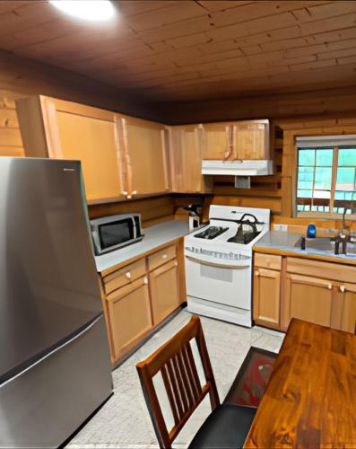 a kitchen with wooden cabinets and a white stove top oven at Box Canyon Cabins in Seward