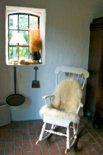 a white rocking chair in a room with a window at Trolleberg Bed & Breakfast in Veberöd