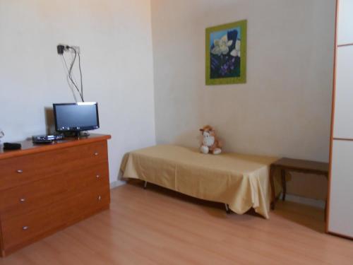 a bedroom with a bed and a dresser with a television at Piccola Azzurra in Comiso