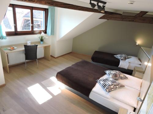 Un dormitorio con dos camas y un escritorio y ventana. en Auberge Communale de St-Légier, en Vevey