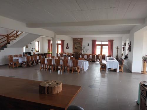a dining room with tables and chairs and windows at Gospodarstwo Agroturystyczne Bogdanówka in Rossosz