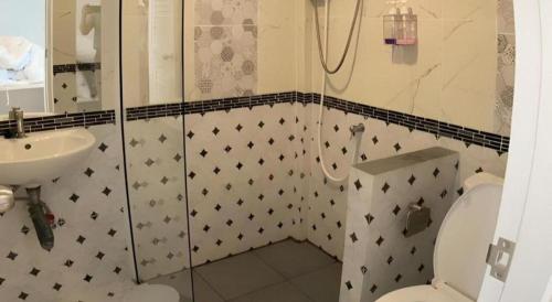 a bathroom with a shower and a toilet and a sink at Thong Prachok Hotel in Sakon Nakhon