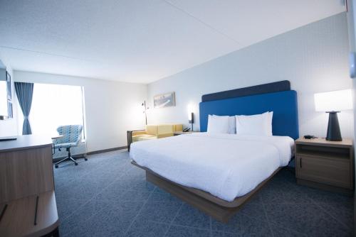 a hotel room with a large bed and a desk at Hampton Inn Chicago-Carol Stream in Carol Stream