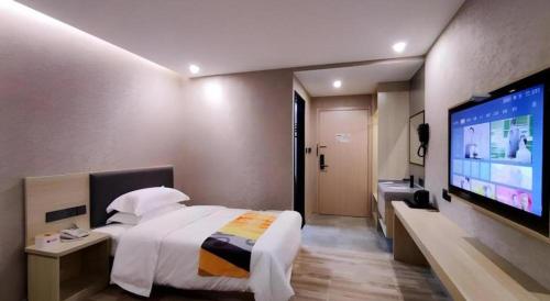 a hotel room with a bed and a flat screen tv at Shell Hotel Wuxi Huishan District Chang'an Town in Wuxi