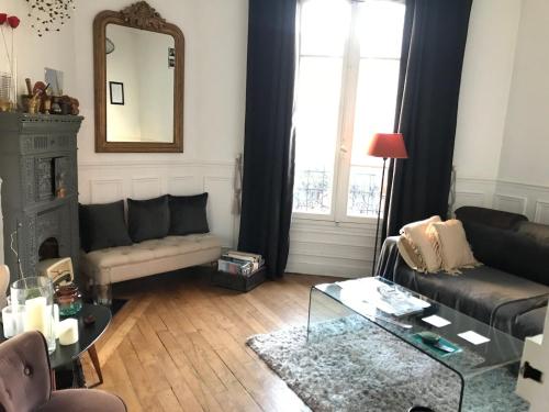 a living room with a couch and a table at Appartement charmant à 5 minutes du métro in Les Lilas