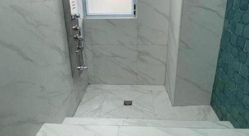 a bathroom with a shower with a glass door at Sunny Day Hotel in Hong Kong