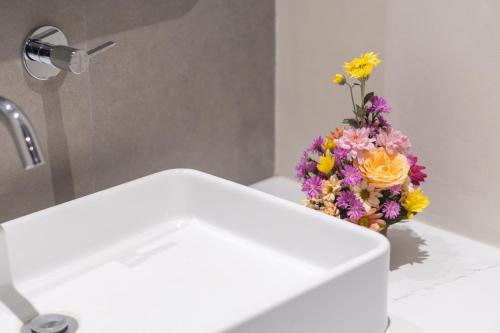a vase of flowers sitting on top of a sink at Pondok Tis Bisma in Ubud