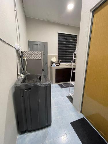 a room with a trash can and a desk at JSS Homestay in Jertih