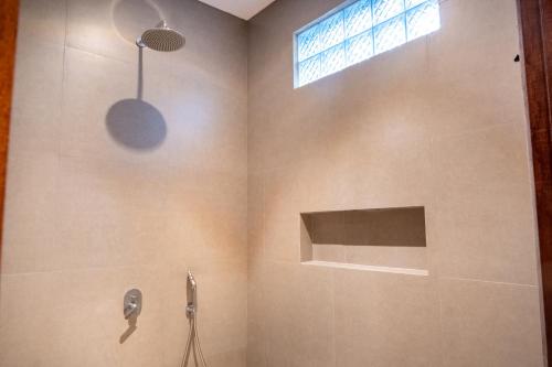 a bathroom with a shower with a window at Pondok Tis Bisma in Ubud