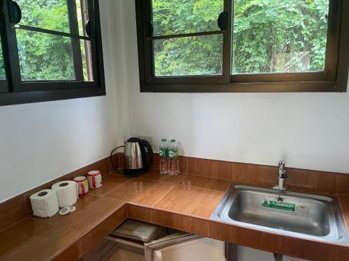 a kitchen counter with a sink and two windows at Lonely Beach Pool Resort in Ko Chang