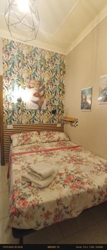 a bedroom with a bed with a floral wallpaper at EnjoyCasa Tra Sole Mare e L'Etna in Adrano