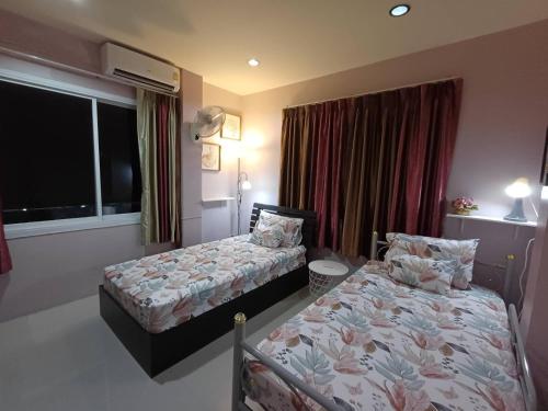a hotel room with two beds and a window at 168Hostel Airport@Phuket in Thalang