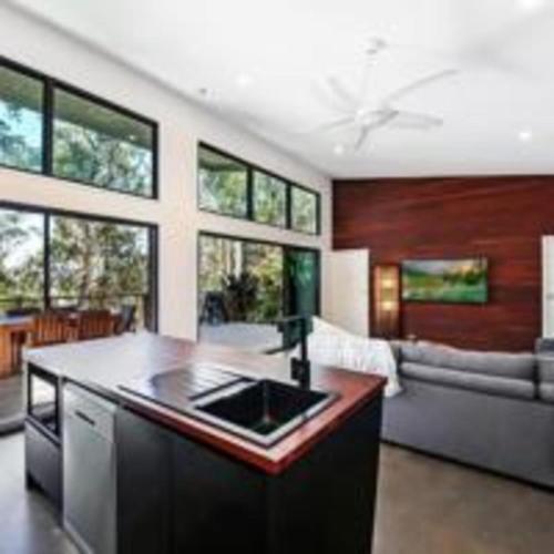 a kitchen with a counter top and a living room at Hunchy Escape - Hinterland Pet Friendly! in Montville