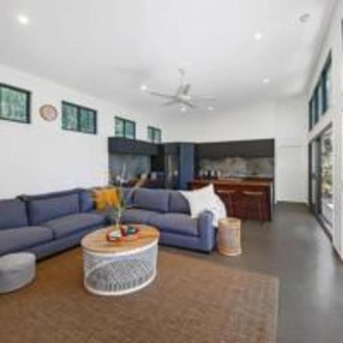 a living room with a blue couch and a table at Hunchy Escape - Hinterland Pet Friendly! in Montville