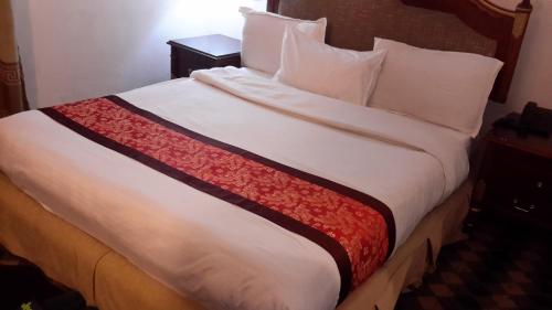 a bedroom with a large bed with white sheets and pillows at DV Guest House 2 in Addis Ababa