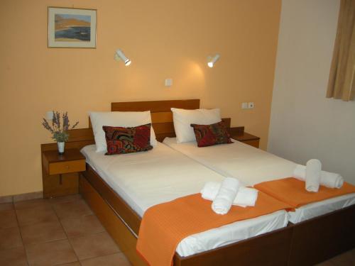 a bedroom with two beds with orange and white sheets at Muses in Neos Marmaras