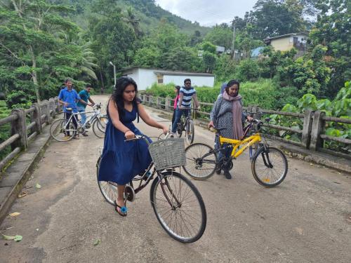 a group of people riding bikes on a bridge at Kit Cott Resort and Retreat in Teligama