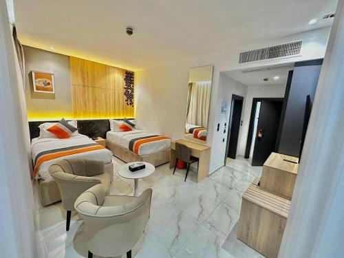 a hotel room with two beds and a living room at Diamond Palm Hotel & Resort in Al Burj