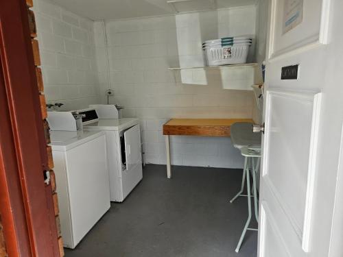 a small white kitchen with a counter and a table at Cleveland Motor Inn in Cleveland