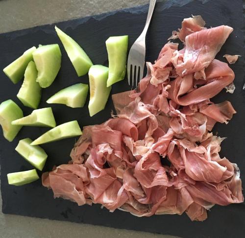 a cutting board with meat and apples and a fork at Villa Art'è in Locarno