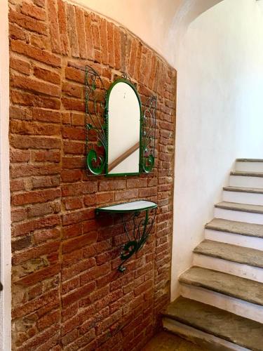 a brick wall with a mirror and a staircase at Cascina Nuova in Mombasiglio
