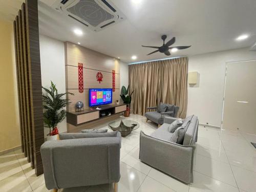 a living room with couches and a flat screen tv at Pangkor Villa 16 Homestay 4Rooms 3Bathroom Free WIFI & Karaoke in Pangkor