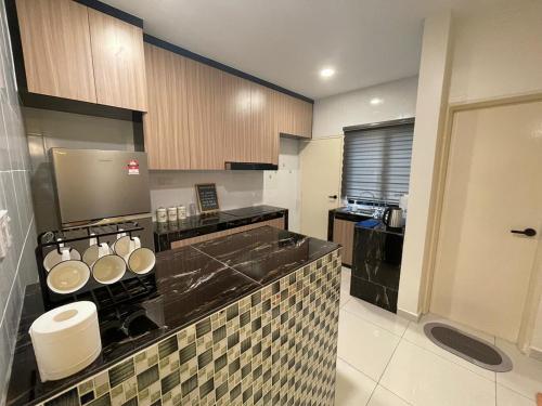 a kitchen with a black counter top with pots and pans at Pangkor Villa 16 Homestay 4Rooms 3Bathroom Free WIFI & Karaoke in Pangkor