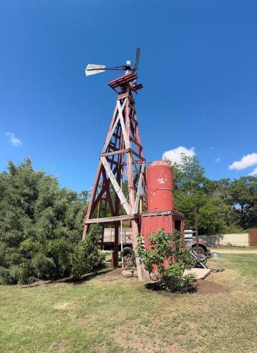 a windmill sitting in the middle of a field at THE CW HOUSE in Claude