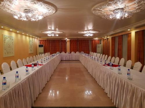 a row of tables in a room with white chairs at Hotel Intercontinental Kabul in Kabul